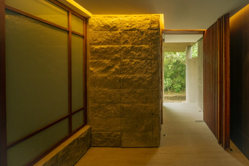 Threshold House interior passage with textured stone and timber